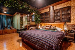 - une chambre avec un grand lit dans l'établissement 26Life Ethnic Trail Yunnan Ethnic Creative Inn, à Jinghong