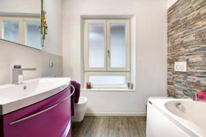 a bathroom with a sink and a tub and a window at Belcantone in Grandola ed Uniti +11 photos