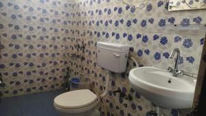 La salle de bains est pourvue de toilettes et d'un lavabo. dans l'établissement Neeraj Homestay, à Dharamshala
