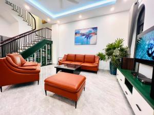 un salon avec deux canapés et une télévision dans l'établissement 3 bedrooms in the Villa - Vinhome Ocean Park, à Gia Lâm Pho