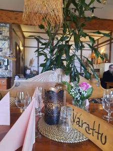 un tavolo in un ristorante con un vaso di fiori di Sininen Hetki Bed& Breakfast majoitus meren äärellä a Kaskö