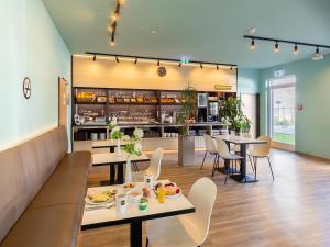 a restaurant with tables and chairs and a counter at B&B Hotel Neuss in Neuss