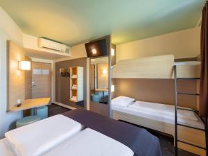 1 dormitorio con 2 literas y escritorio en B&B Hotel Neuss en Neuss