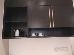 a black kitchen cabinet with pots and pans on top of a refrigerator at Bukit Bintang Axon 3R2B HiFloor wt Parking in Kuala Lumpur