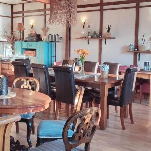una sala da pranzo con tavoli e sedie in legno di Sininen Hetki Bed& Breakfast majoitus meren äärellä a Kaskö