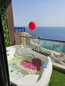 a bath tub with a red balloon on a balcony at برج داماك الجوهرة جدة , الجناح الذهبي-Damac jawharah tower in Jeddah