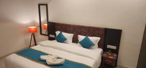a bedroom with a bed with blue and white pillows at Green Club Farm in Ajmer