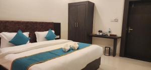 a bedroom with two beds with blue and white pillows at Green Club Farm in Ajmer