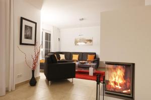 a living room with a couch and a fireplace at Strandvilla "Babette" - BALO B, direkt am Meer, mit Sauna in Lobbe