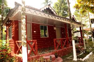 a house with a red fence in front of it at Ayush Jungle Resort in Jalpāiguri