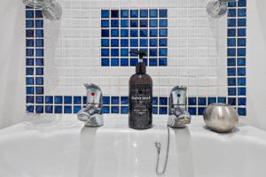 a bathroom sink with a bottle of soap on it at Cosy 1-Bed Apartment in Central London Old Street in London