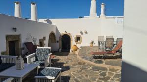 a patio with chairs and tables and a building at VILLA MITATA CYTHERE in Mitáta