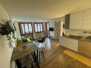 a kitchen and a living room with a table and a kitchen at Le Bon Bon CIR-TORGNON-0017 in Torgnon