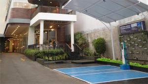 een gebouw met een tennisbaan ervoor bij Luminor Hotel Purwokerto By WH in Purwokerto