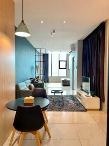 een woonkamer met een tafel en een bank bij Hush Inn at ITCC Manhattan Suites in Kota Kinabalu