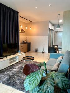 sala de estar con sofá y TV en Hush Inn at ITCC Manhattan Suites, en Kota Kinabalu