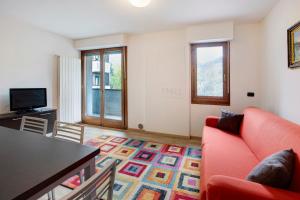 ein Wohnzimmer mit einem roten Sofa und einem Tisch in der Unterkunft Le Sorgenti in Valdisotto