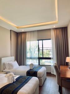 ein Hotelzimmer mit 2 Betten und einem Fenster in der Unterkunft Sunshine Garden Hotel in Ban Pa Chi
