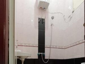 y baño con ducha, lavamanos y cabezal de ducha. en Hotel 889 Syariah Redpartner Banda Aceh, en Banda Aceh