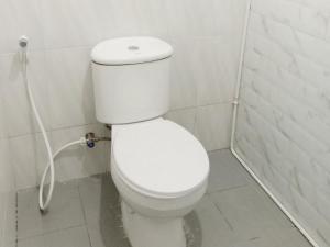 Un baño con un inodoro blanco en una cabina. en Hotel 889 Syariah Redpartner Banda Aceh, en Banda Aceh