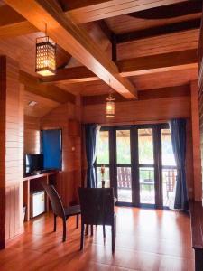 - une salle à manger avec une table, des chaises et des fenêtres dans l'établissement Baan Laanta Resort & Spa - SHA PLUS, à Ko Lanta