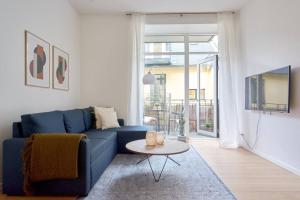 a living room with a blue couch and a table at Nordic style top location balcon in Copenhagen