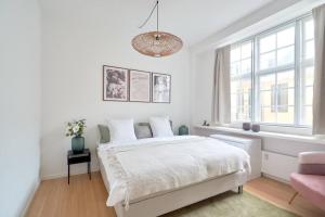 a white bedroom with a bed and a window at Nordic style top location balcon in Copenhagen