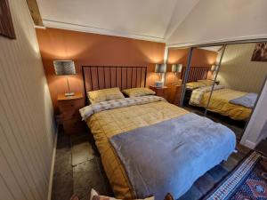 a small bedroom with two beds and a mirror at Coopers Cottage in Peterhead