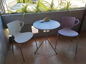 duas cadeiras e uma mesa em frente a uma janela em PPS.Guest House em Lopburi