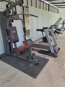 un gimnasio con varias máquinas de correr en una habitación en PPS.Guest House en Lop Buri