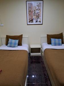 dos camas sentadas una al lado de la otra en una habitación en PPS.Guest House en Lop Buri