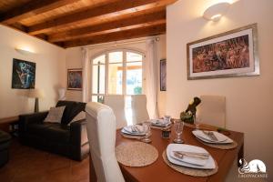 een woonkamer met een tafel en een bank bij Borgo del Torchio - App. 5H in Manerba del Garda