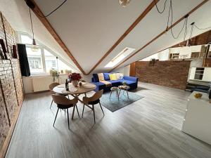 sala de estar con mesa y sofá azul en ACME Apartments en Budapest