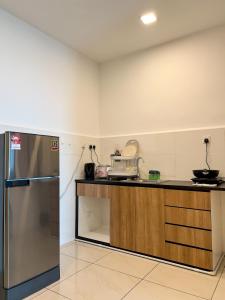 una cucina con bancone e frigorifero di Hush Inn at ITCC Manhattan Suites a Kota Kinabalu