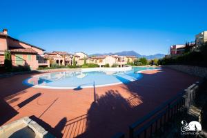 een groot zwembad in een tuin met huizen bij Borgo del Torchio - App. 5H in Manerba del Garda