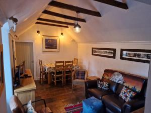 een woonkamer met een bank en een tafel bij Coopers Cottage in Peterhead