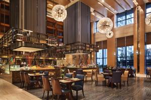 Huangshi的住宿－黃石萬達嘉華酒店，餐厅设有桌椅和吊灯。