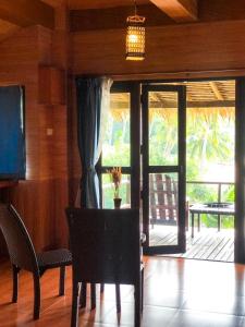 a dining room with a table and chairs and a sliding glass door at Baan Laanta Resort & Spa - SHA PLUS in Ko Lanta