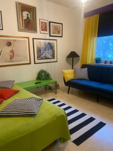 una camera con un letto verde e un divano blu di Värikäs puutalokaksio 1-6 hlölle, ilm parkit a Oulu