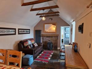 sala de estar con sofá y chimenea en Coopers Cottage, en Peterhead