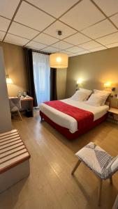 a bedroom with a large bed with a red blanket at Logis Hôtel Restaurant Azalées in Tournon-sur-Rhône