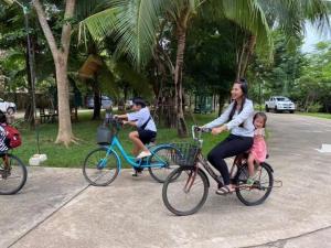 Dos personas montando en bicicleta con un niño en una cesta en VANA Wellness Resort, 
