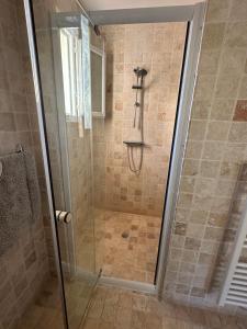a shower with a glass door in a bathroom at LES CLÉMATITES in Donzère +8 photos