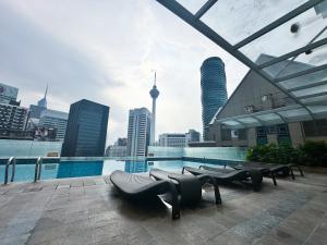 a pool with a view of a city and buildings at Pavilion Suites KLCC Bukit Bintang at Cormar by NHB in Kuala Lumpur