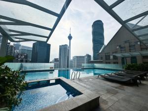 a swimming pool with a view of the city at Pavilion Suites KLCC Bukit Bintang at Cormar by NHB in Kuala Lumpur