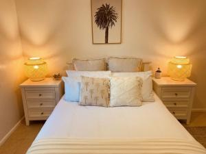 a bedroom with a white bed with two night stands at Sandcastles in Barrack Point