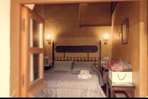 Un dormitorio con una cama con un osito de peluche. en APARTAMENTOS RURAL LA JACOBA, en Cabezuela del Valle