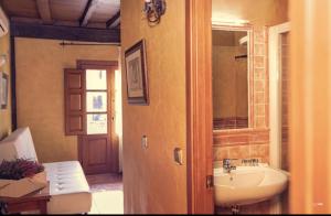 y baño con lavabo y espejo. en APARTAMENTOS RURAL LA JACOBA, en Cabezuela del Valle