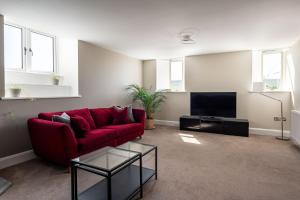 uma sala de estar com um sofá vermelho e uma televisão em The Old Chapel em Leyburn