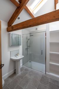 uma casa de banho com uma cabina de duche em vidro e um lavatório. em The Old Chapel em Leyburn